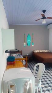 a room with two beds and a table and a chair at Suites do Rafa Ubatuba in Ubatuba