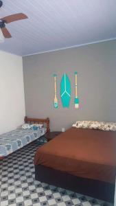 a bedroom with two beds and instruments on the wall at Suites do Rafa Ubatuba in Ubatuba