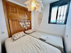 - un lit avec deux oreillers dans une chambre dotée d'une fenêtre dans l'établissement Sunshine Home Competa, à Cómpeta