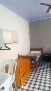 a room with a bed and a desk and a chair at Suites do Rafa Ubatuba in Ubatuba