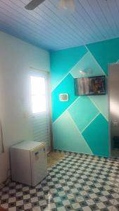 a room with a blue wall and a window at Suites do Rafa Ubatuba in Ubatuba