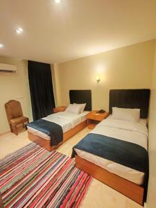 سرير أو أسرّة في غرفة في Kush Hotel, Grand Museum & Pyramids View