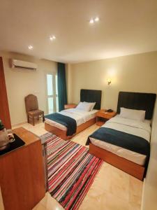 سرير أو أسرّة في غرفة في Kush Hotel, Grand Museum & Pyramids View