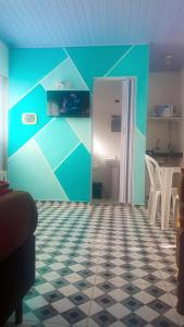 a room with a blue wall and a table and chairs at Suites do Rafa Ubatuba in Ubatuba