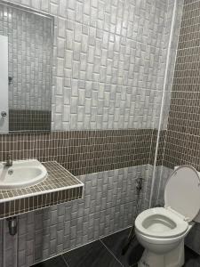 een badkamer met toilet en wastafel bij Saint Jira Hotel in Chum Phae