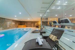 a swimming pool with chairs next to a swimming pool at Hyatt Buyutat Serviced Apartments in Riyadh