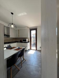 ベルガモにあるLa casa di Nina, vista sui colli di Bergamo Golfの白いキャビネットとテーブルと椅子のあるキッチン