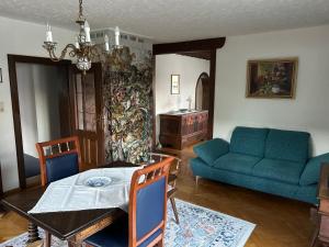a living room with a table and a blue couch at Haus Födinger in Altmünster
