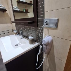 a bathroom with a sink and a hair dryer on the wall at Nules Beach Apartment in Moncófar +18 photos