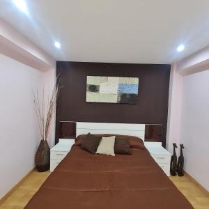 a bedroom with a large bed with a brown headboard at Nules Beach Apartment in Moncófar