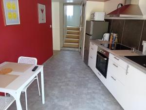 a kitchen with a table and a white counter top at Au Bonheur du Puy in Moutiers-sur-le-Lay