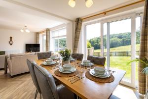 a dining room with a table and chairs and a large window at FernLea - Cosy bungalow and stunning country views in Glaisdale
