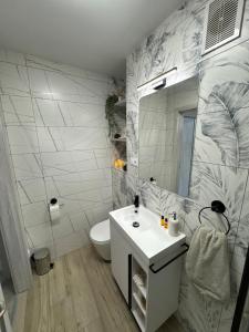 a white bathroom with a sink and a toilet at Seaside Apartment in Gdańsk +9 photos