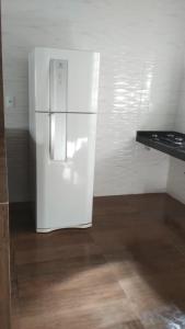 a white refrigerator in a room with a wooden floor at Jardim Secreto in Piumhi