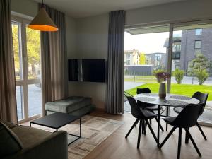 ein Wohnzimmer mit Tisch und Stühlen in der Unterkunft MiMi Palanga - Self Check-in in Palanga