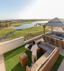 a man standing on a balcony with a view of a golf course at بنتهاوس فاخر بإطلالة مزدوجة في مراسي بلانكا in El Alamein