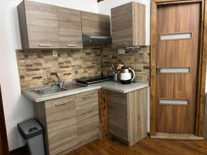a kitchen with wooden cabinets and a sink and a door at 4 you in Levoča