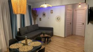 un soggiorno con un divano e un tavolo di Cataleya Blue a Mamaia Nord - Năvodari