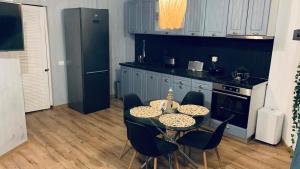 una cucina con un tavolo con sedie e un frigorifero nero di Cataleya Blue a Mamaia Nord - Năvodari Altre 5 foto