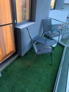 tre sedie appoggiate sul pavimento in una stanza con l'erba di Cataleya Blue a Mamaia Nord - Năvodari