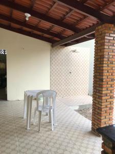a white table and two chairs on a patio at Refúgio do Mar in Beberibe +12 photos