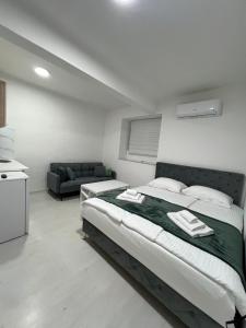 una camera da letto con un letto grande e un divano di Central Park Residence a Sarajevo