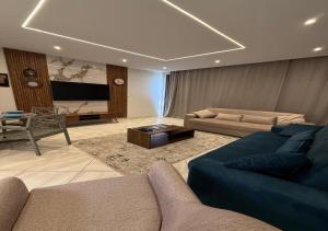 a large living room with a couch and a television at بنتهاوس فاخر بإطلالة مزدوجة في مراسي بلانكا in El Alamein
