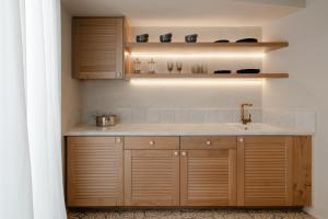 a kitchen with wooden cabinets and a sink at Castellum Suites in Naxos Chora +25 photos