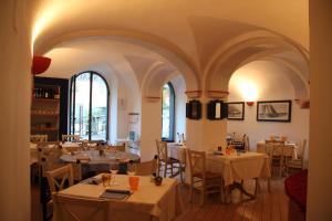 a restaurant with white tables and chairs and windows at Hotel Argentina in Santa Margherita Ligure
