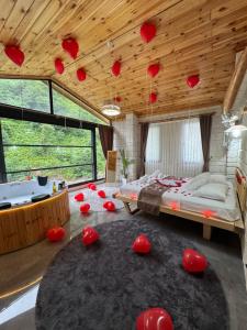 a bedroom with red hearts hanging from the ceiling at Villa Del Rio Karadeniz River Palace Ayder in Çamlıhemşin