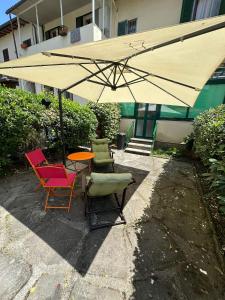 Camera da letto Wilma في فلورنسا: طاولة وكراسي تحت مظلة كبيرة