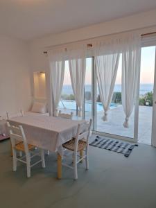 a white room with a table and chairs and a window at Villa Constantinos in Koutsounari