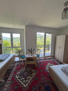 una stanza con due letti, un tavolo e finestre di Konak Umoljani a Umoljani