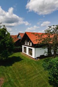 a white house with an orange roof on a yard at Ferienunterkunft Heimatfleckerl in Geisenhausen