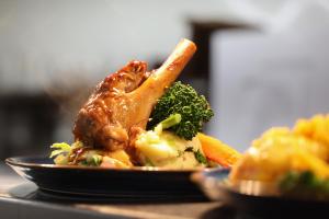 a plate of food with meat and vegetables on a table at The Gables in Carland +2 photos