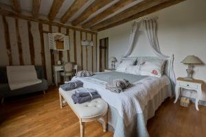 a bedroom with a white bed with a canopy at Chambres d'hôtes Le Theil in Blois