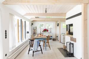 a kitchen and dining room with a table and chairs at Urgemütliche Reetdachkate mit großem Kamin und Sauna in Pommerby +23 photos