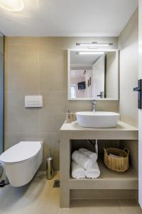 a bathroom with a sink and a toilet and a mirror at Bleu & Vert in Skopelos Town +40 photos