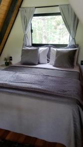 a large bed in a room with a window at Chalés Sol da Serra - Eucalipto in Rio Rufino