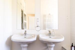 a white bathroom with two sinks and a mirror at Appartement T4 centre-ville St Nazaire in Saint-Nazaire +19 photos