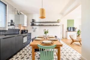 a kitchen with a wooden table and chairs at Appartement T4 centre-ville St Nazaire in Saint-Nazaire