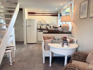 a kitchen with a table and a refrigerator in a room at Ferienwohnung MALIBU S am See in Wettringen +13 photos