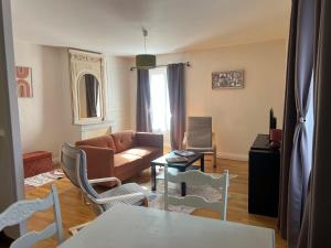 una sala de estar con un sofá y sillas en Joli duplex plein centre, parking sur demande à la réservation, en Issoire 9 fotos más