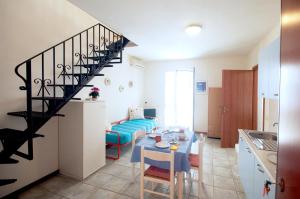 a kitchen and a living room with a spiral staircase at Residence Loggetta Margherita in San Vincenzo