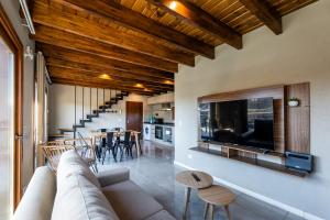 Una sala de estar con un sofá y un comedor. en CIERVO - Departamento céntrico, en Villa La Angostura