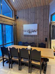 a dining room with a wooden table and chairs at New Mountain Cabin in Trysil Knuts Fjellworld in Jordet