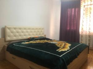 a bedroom with a bed with a dragon comforter at Orion apartment in Pristina