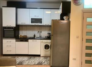 a kitchen with a refrigerator and a washing machine at Orion apartment in Pristina +12 photos