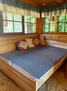 a large bed in a room with windows at Chalúpka u líšky Elišky in Ždiar