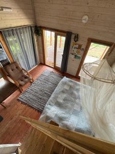 a living room with a table and a rug at Jazinka Sunrise 2 in Apšenieki